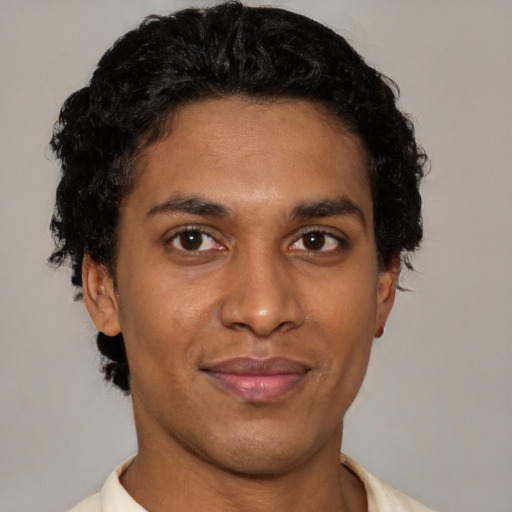Joyful latino young-adult male with short  brown hair and brown eyes