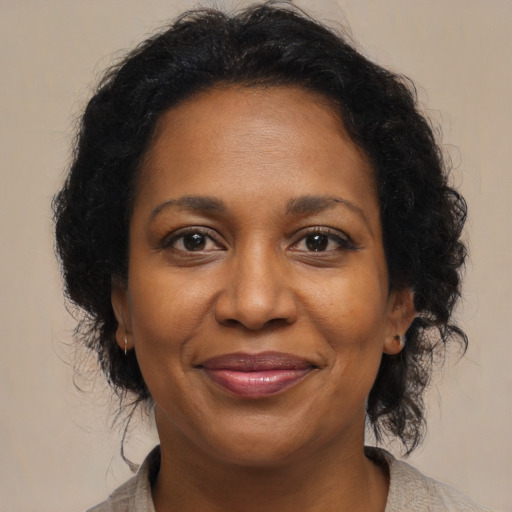 Joyful black adult female with medium  brown hair and brown eyes