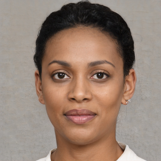 Joyful black young-adult female with short  black hair and brown eyes