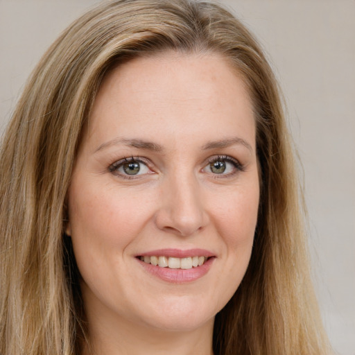 Joyful white young-adult female with long  brown hair and green eyes