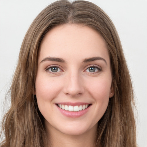 Joyful white young-adult female with long  brown hair and green eyes