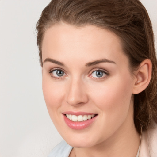 Joyful white young-adult female with long  brown hair and grey eyes