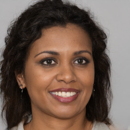 Joyful black young-adult female with medium  brown hair and brown eyes