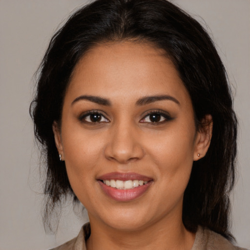 Joyful latino young-adult female with medium  brown hair and brown eyes