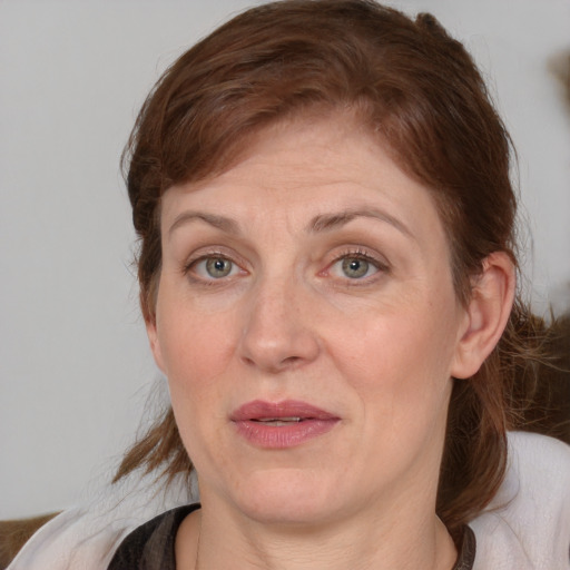 Joyful white adult female with medium  brown hair and blue eyes