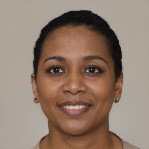 Joyful black young-adult female with short  brown hair and brown eyes