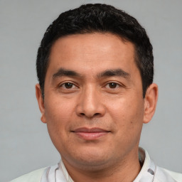 Joyful white adult male with short  black hair and brown eyes