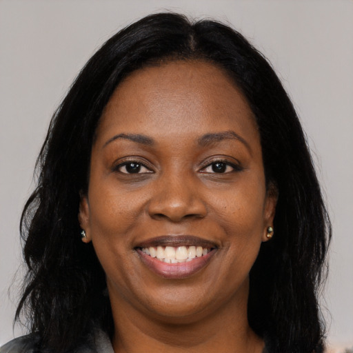 Joyful black young-adult female with long  black hair and brown eyes
