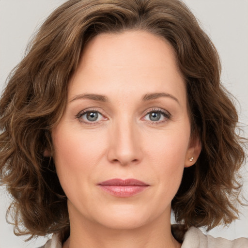 Joyful white young-adult female with medium  brown hair and green eyes