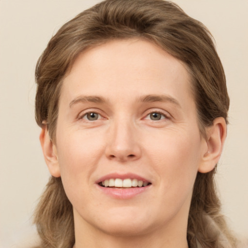 Joyful white young-adult female with long  brown hair and green eyes