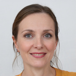 Joyful white young-adult female with medium  brown hair and grey eyes