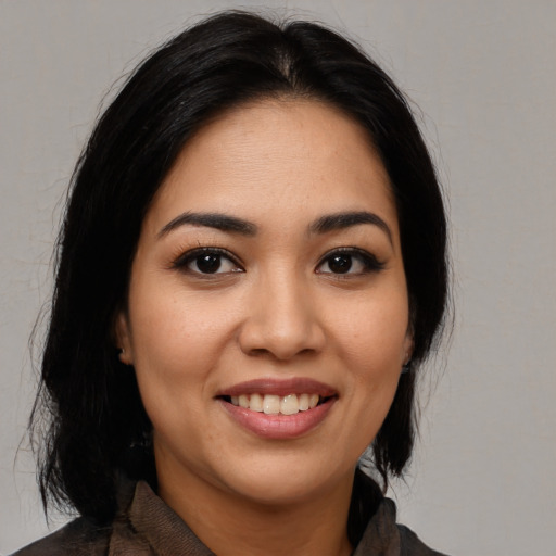 Joyful latino young-adult female with medium  black hair and brown eyes