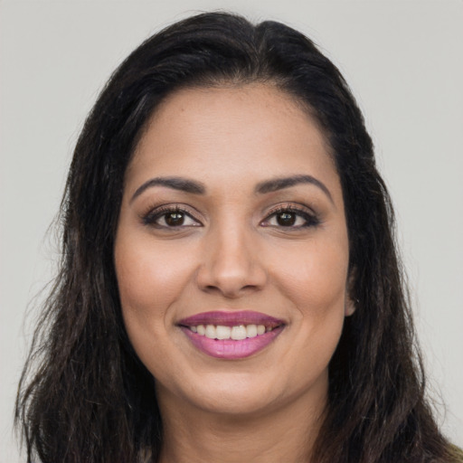 Joyful latino young-adult female with long  brown hair and brown eyes