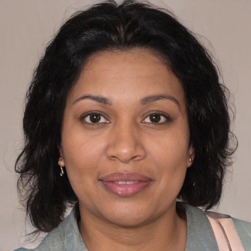 Joyful black adult female with medium  brown hair and brown eyes