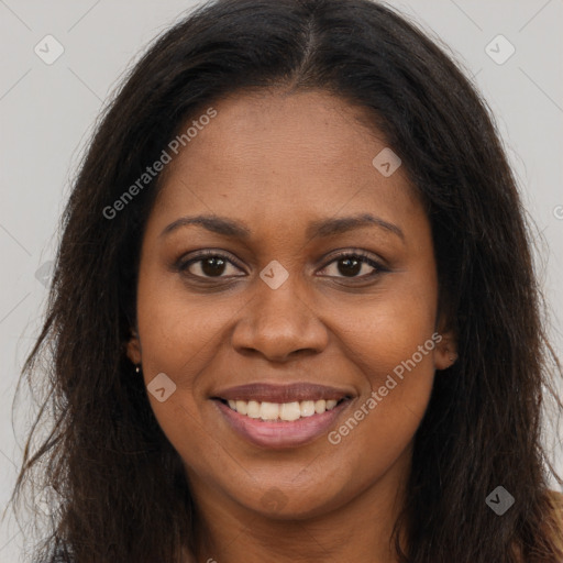 Joyful black young-adult female with long  brown hair and brown eyes