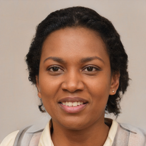 Joyful black young-adult female with short  black hair and brown eyes