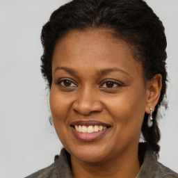 Joyful black young-adult female with long  brown hair and brown eyes