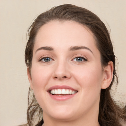 Joyful white young-adult female with long  brown hair and green eyes