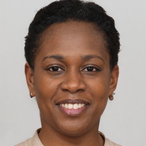 Joyful black young-adult female with short  brown hair and brown eyes