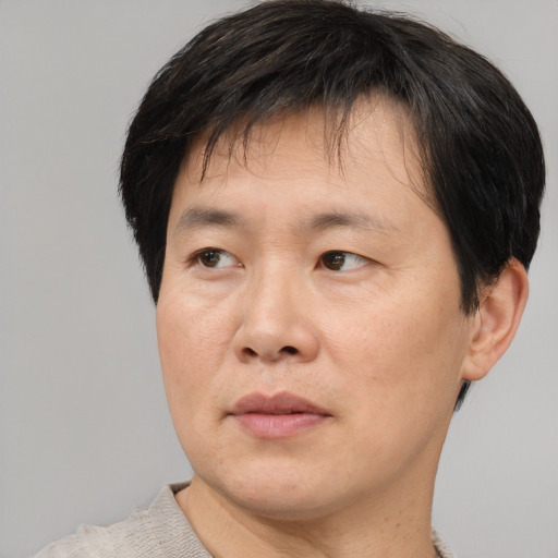 Joyful asian adult male with short  brown hair and brown eyes