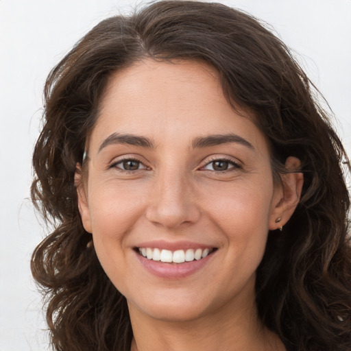 Joyful white young-adult female with long  brown hair and brown eyes