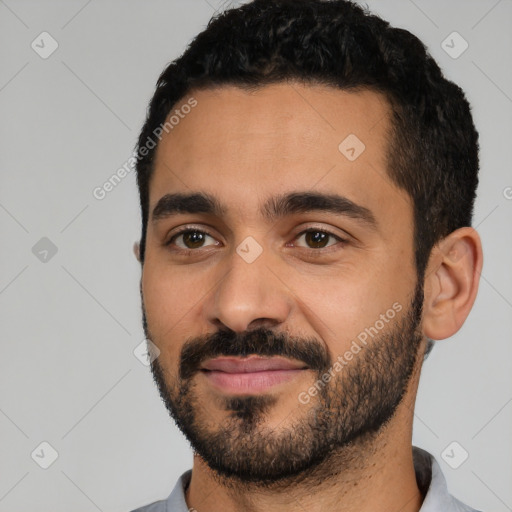 Joyful latino young-adult male with short  black hair and brown eyes