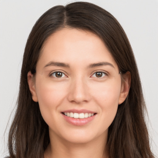 Joyful white young-adult female with long  brown hair and brown eyes