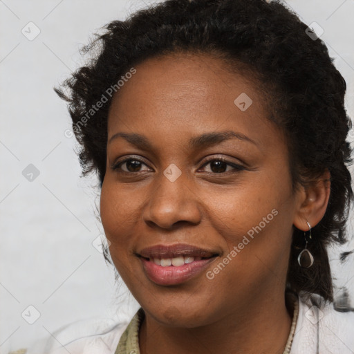 Joyful black young-adult female with long  brown hair and brown eyes