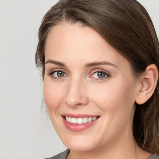 Joyful white young-adult female with medium  brown hair and grey eyes