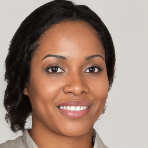 Joyful black young-adult female with medium  brown hair and brown eyes