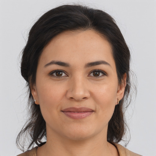 Joyful latino young-adult female with medium  brown hair and brown eyes