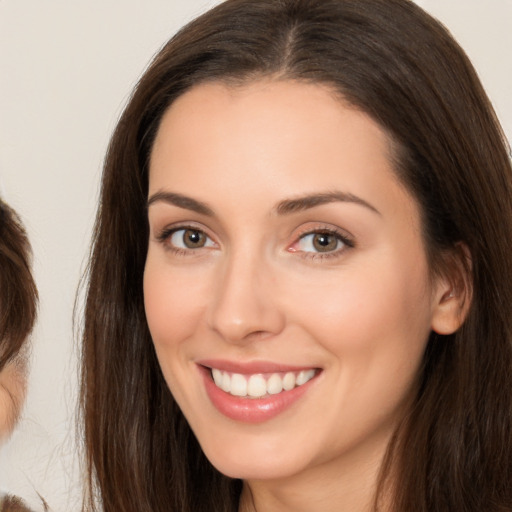 Joyful white young-adult female with long  brown hair and brown eyes