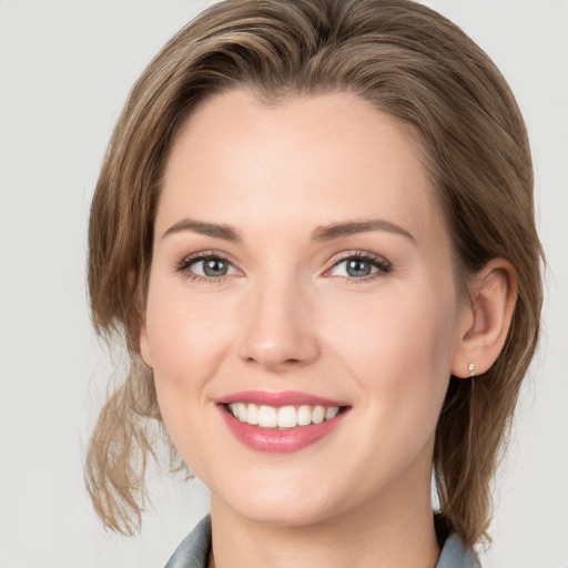 Joyful white young-adult female with medium  brown hair and grey eyes