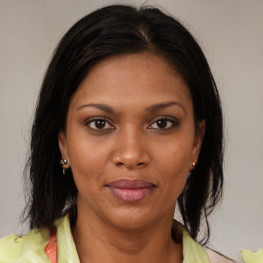 Joyful black young-adult female with medium  brown hair and brown eyes