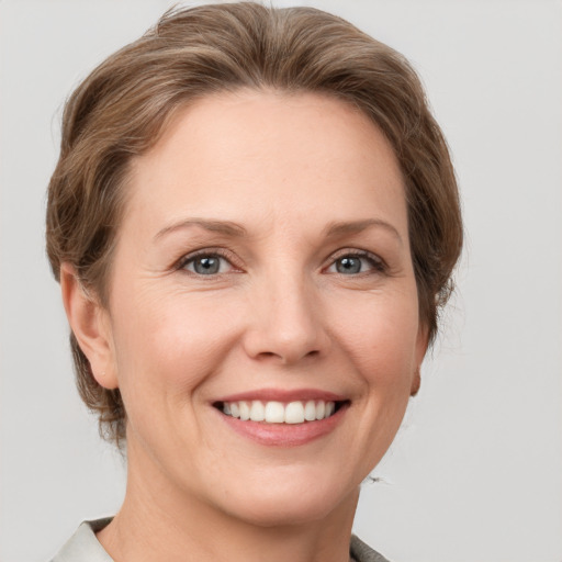 Joyful white young-adult female with short  brown hair and grey eyes