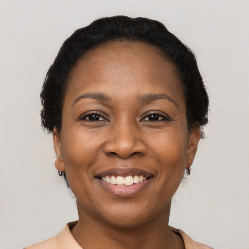 Joyful black adult female with short  black hair and brown eyes