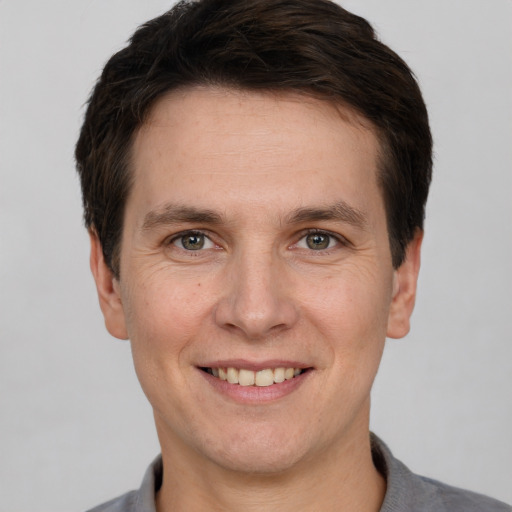 Joyful white adult male with short  brown hair and grey eyes