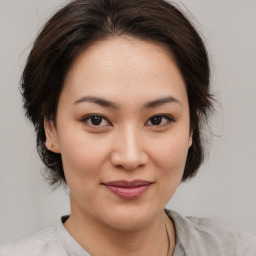 Joyful asian young-adult female with medium  brown hair and brown eyes