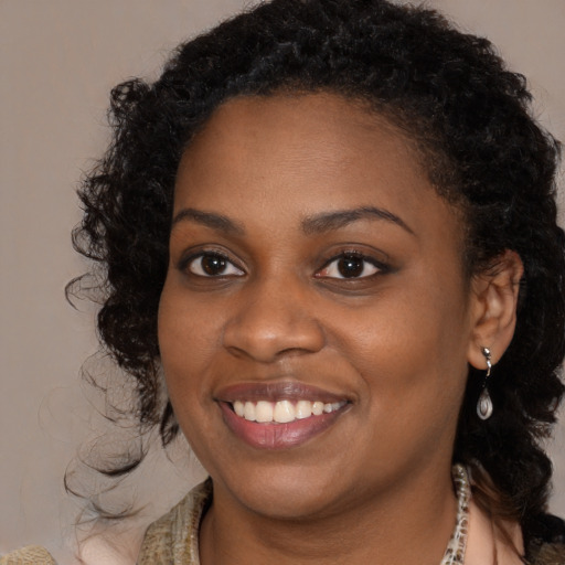 Joyful black young-adult female with medium  brown hair and brown eyes