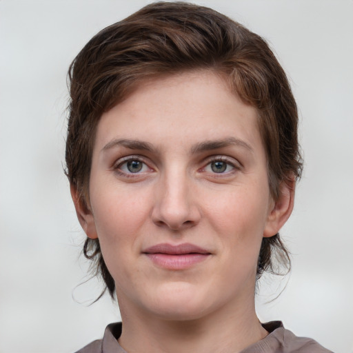 Joyful white young-adult female with medium  brown hair and grey eyes