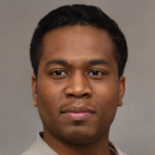 Joyful black young-adult male with short  black hair and brown eyes