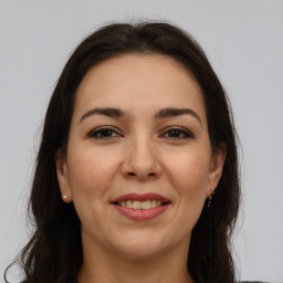 Joyful white adult female with long  brown hair and brown eyes