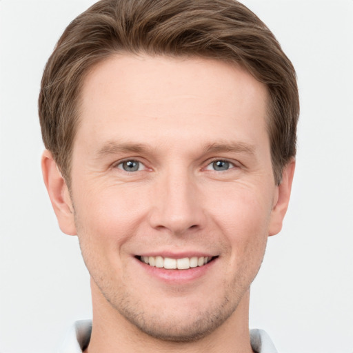 Joyful white young-adult male with short  brown hair and grey eyes