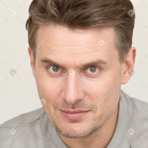 Joyful white adult male with short  brown hair and grey eyes