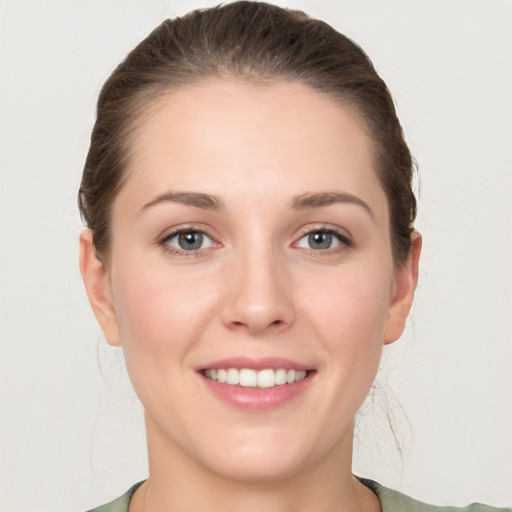 Joyful white young-adult female with medium  brown hair and grey eyes