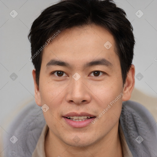 Joyful asian young-adult male with short  brown hair and brown eyes