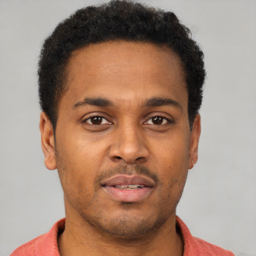 Joyful latino young-adult male with short  brown hair and brown eyes