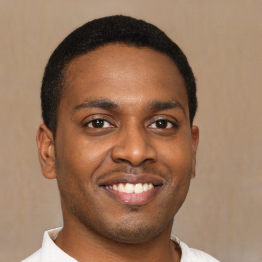 Joyful black young-adult male with short  black hair and brown eyes