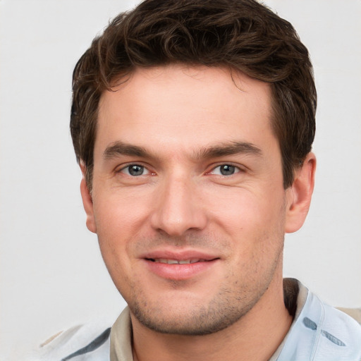 Joyful white young-adult male with short  brown hair and grey eyes