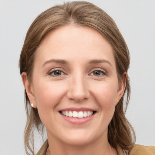 Joyful white young-adult female with medium  brown hair and grey eyes